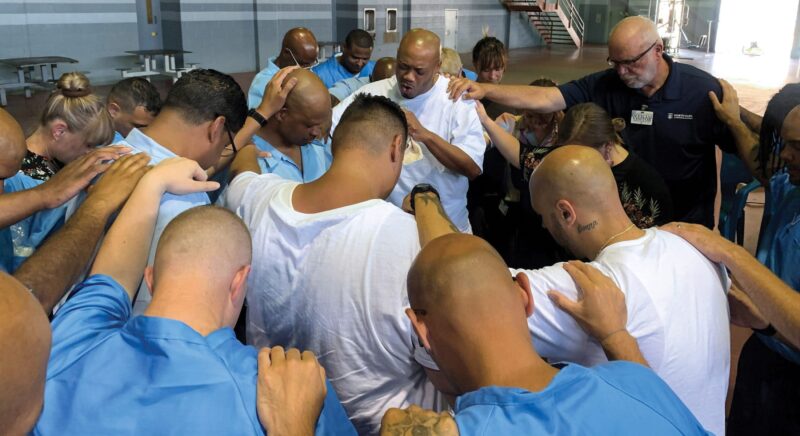 Group of incarcerated students praying together
