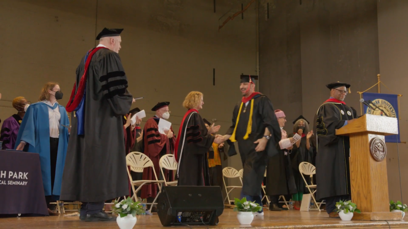 Graduate walks across stage to receive diploma