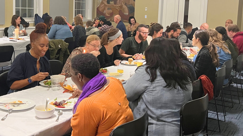 Students and faculty eat together at long table