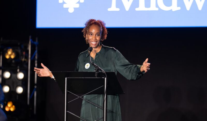 Black woman teaches on the main stage at a conference