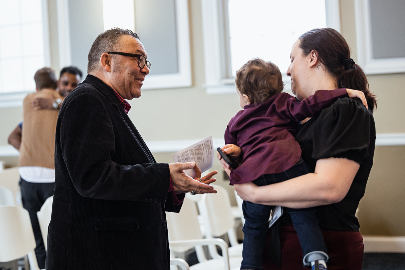 Older student speaks to woman and child in Isaacson Chapel