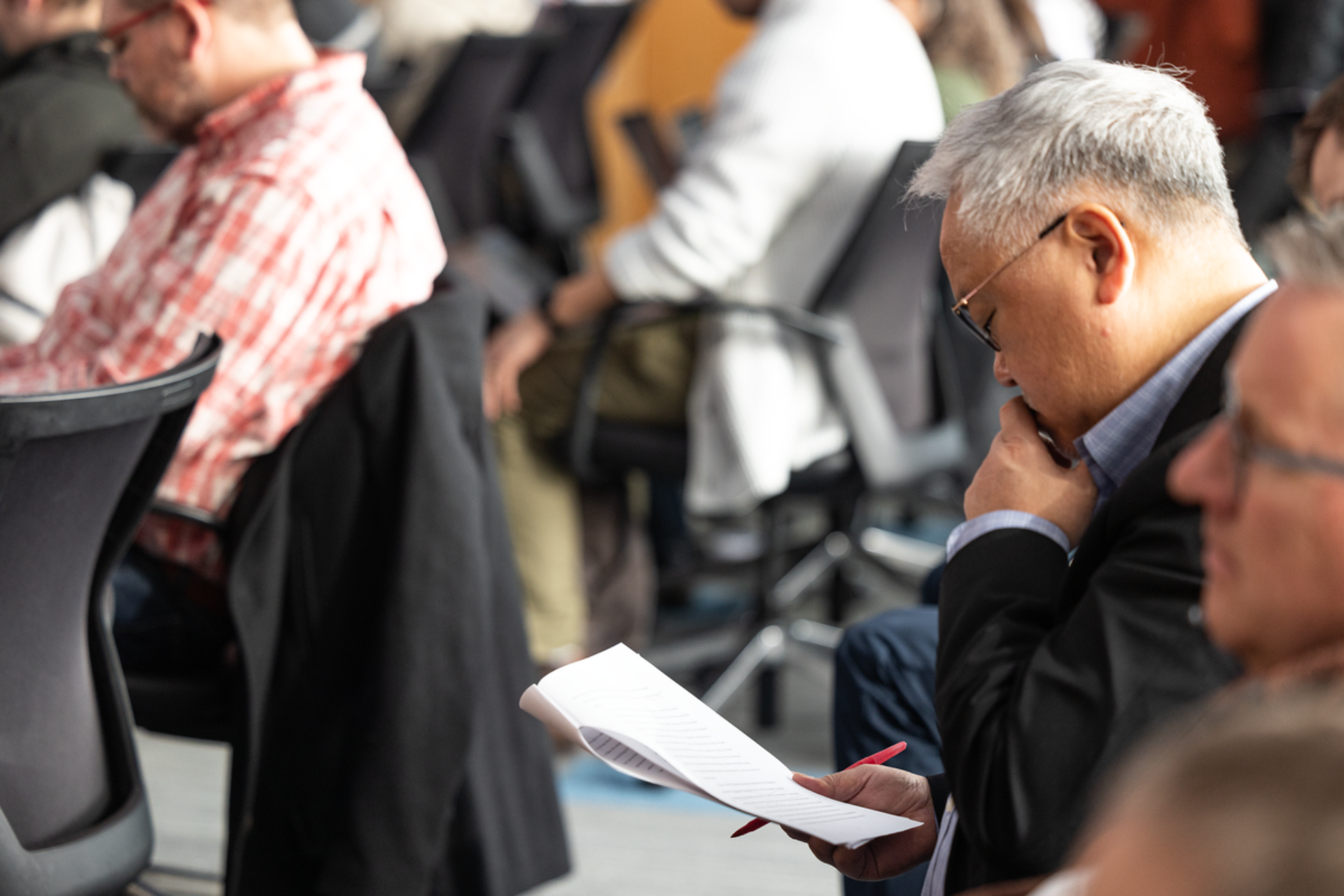 Professor studies an academic paper at a conference
