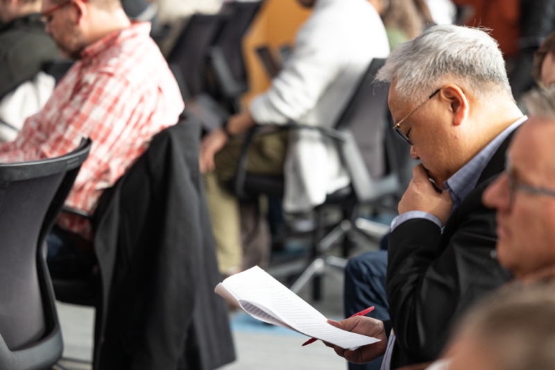 Professor studies an academic paper at a conference