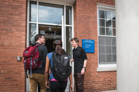 seminary students walk in front door of building labeled Nyvall Hall