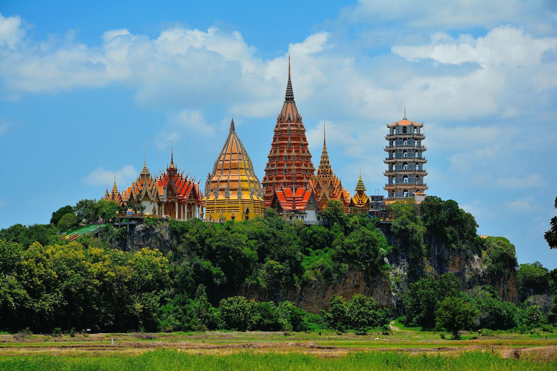 colorful pagoda towers in thailand rise above forest