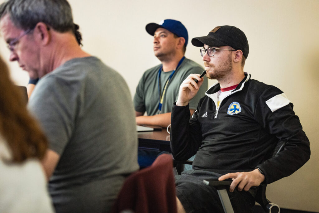 male seminary student sits in classroom looking thoughtful