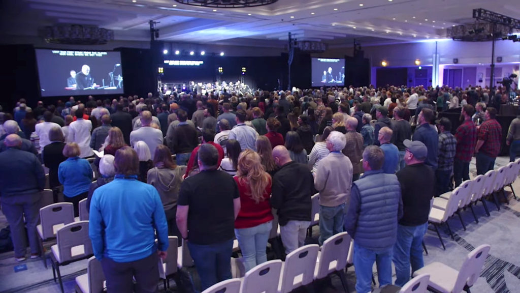 people standing at conference worship session