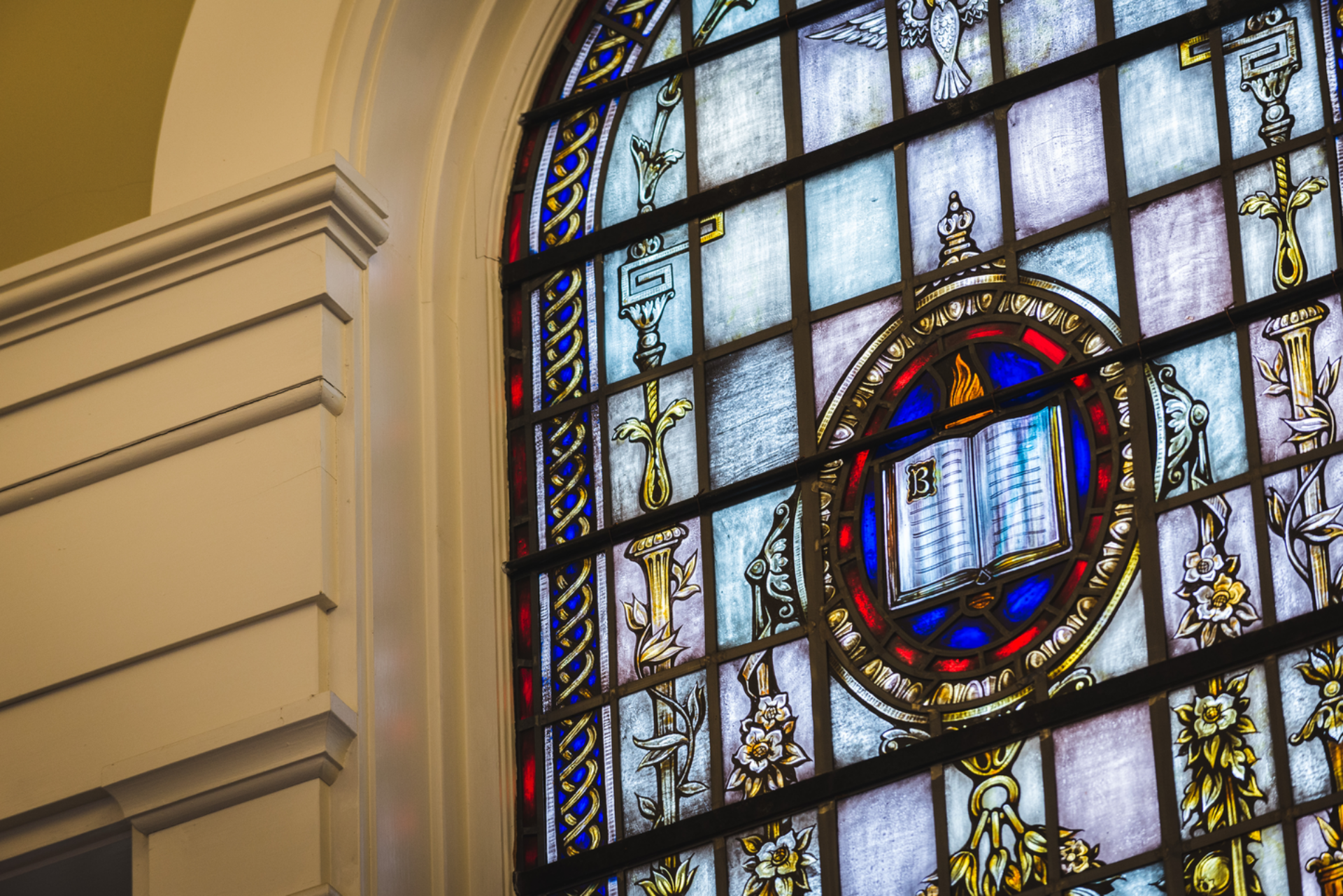 Stained glass in Isaacson chapel displays a picture of the Bible and flame