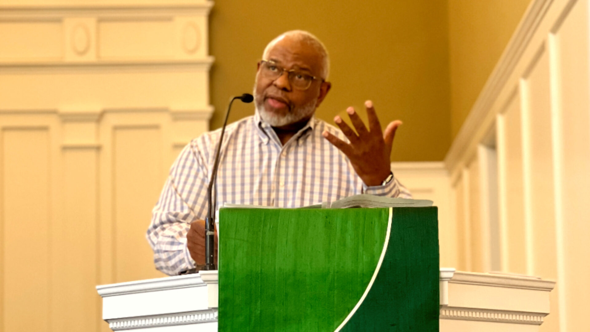 African American preacher behind pulpit delivering a sermon