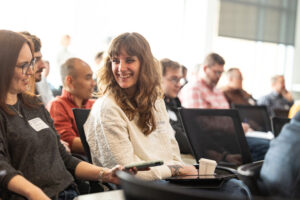 Student symposium participant smiles at fellow student