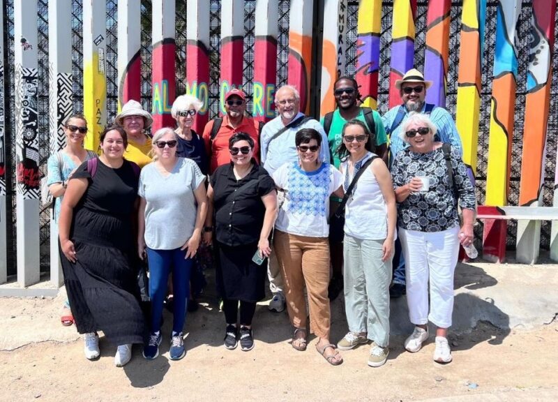 Group stands in front of border wall