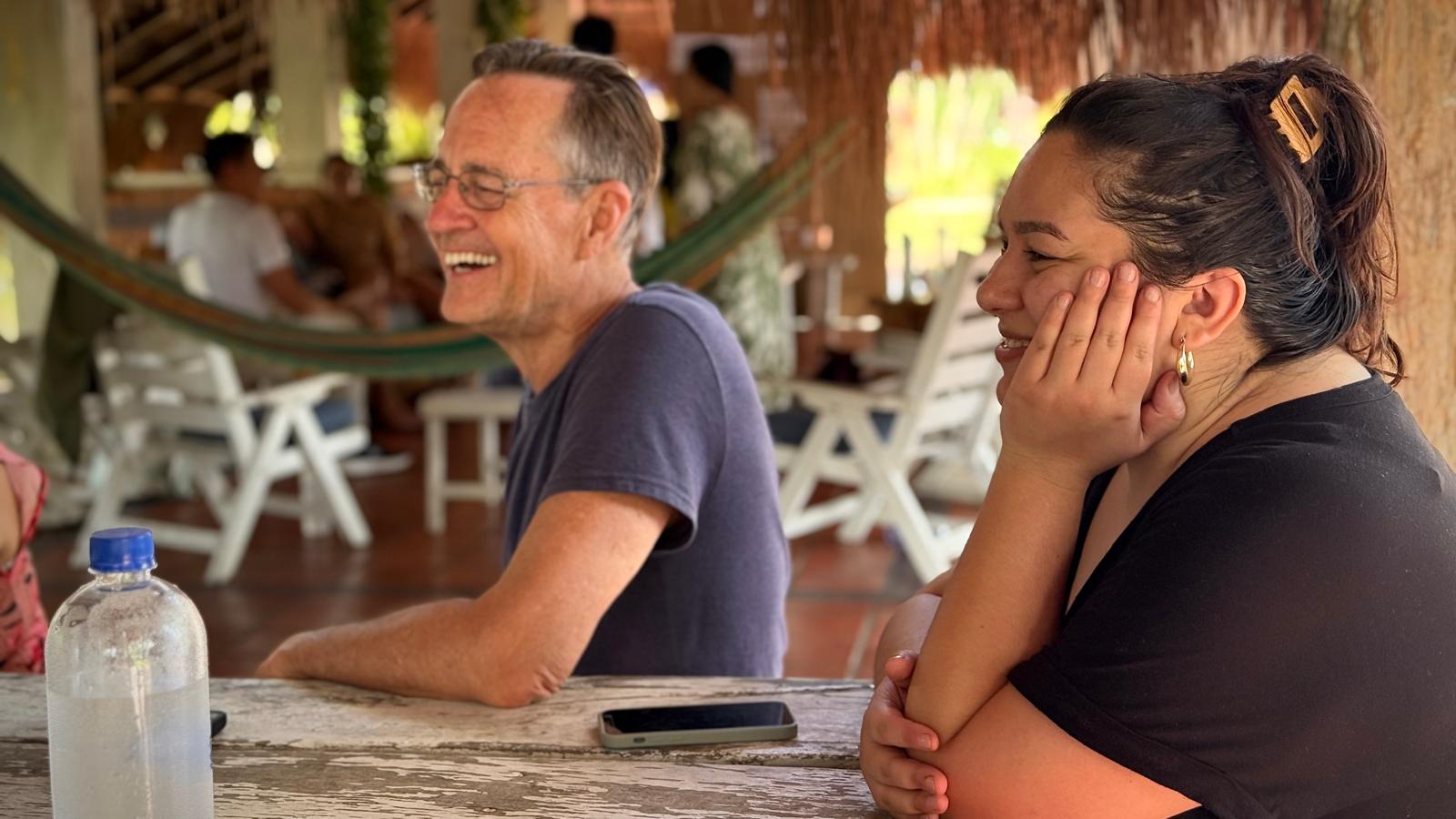 two people sitting face same direction with smiles