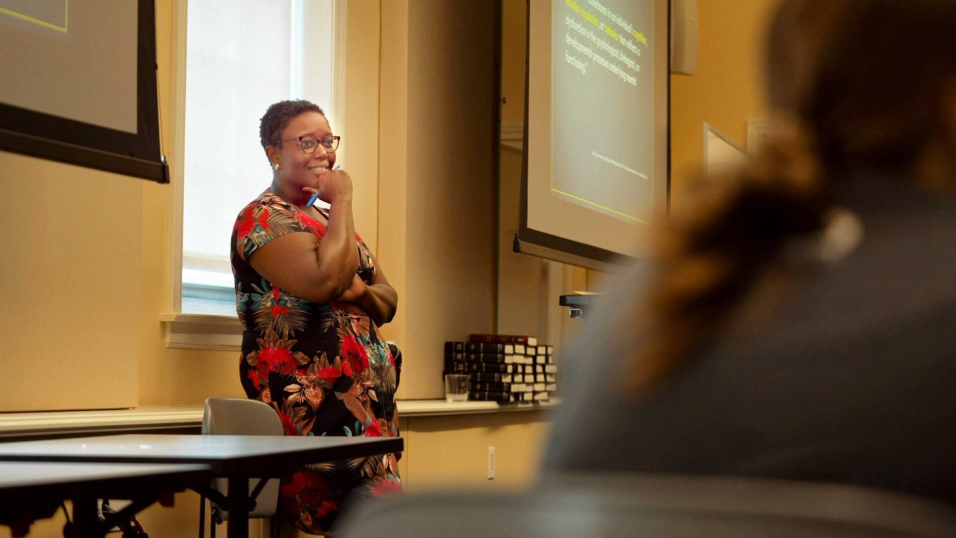 Professor Elizabeth Pierre in front of class listens to student with interest