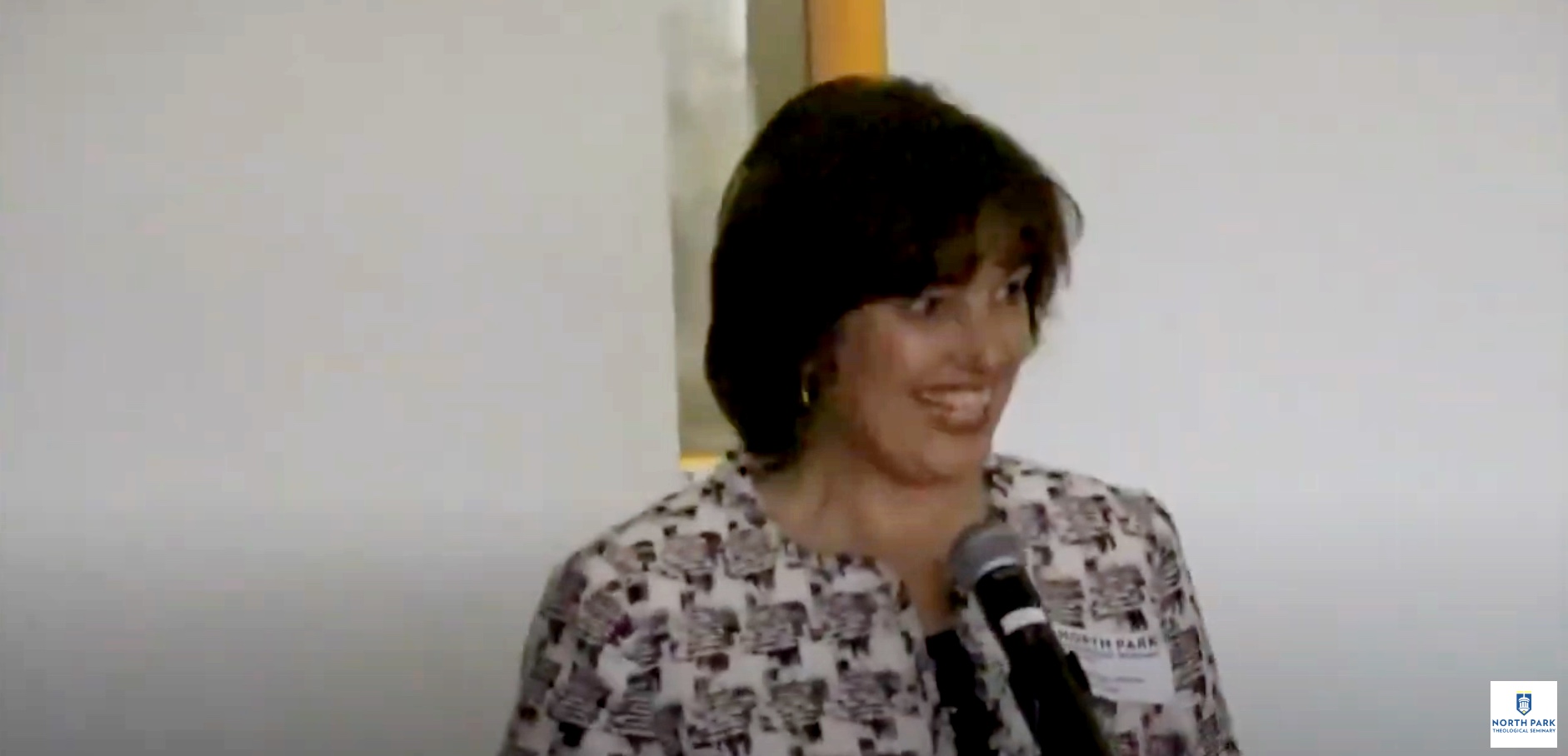 Professor smiles at the audience as she lectures