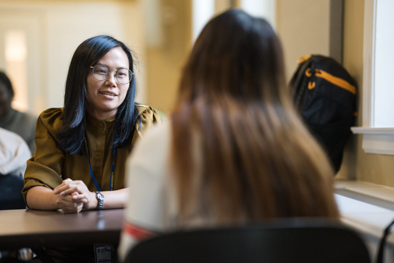 Female Asian professor engages with student