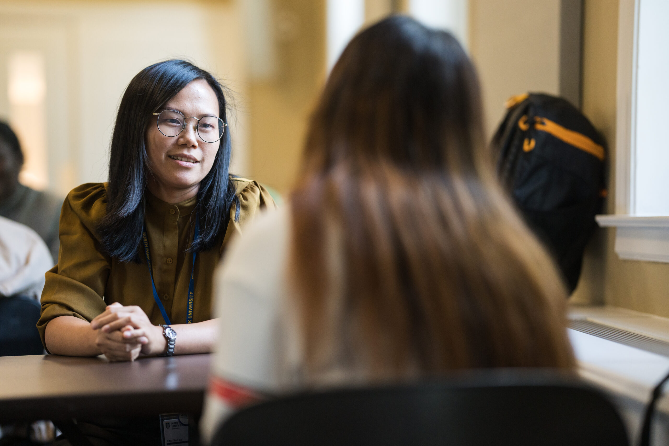 Female Asian professor engages with student