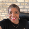 Black woman wearing red lipstick smiles at the camera