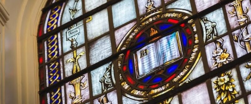 stained glass window featuring bible