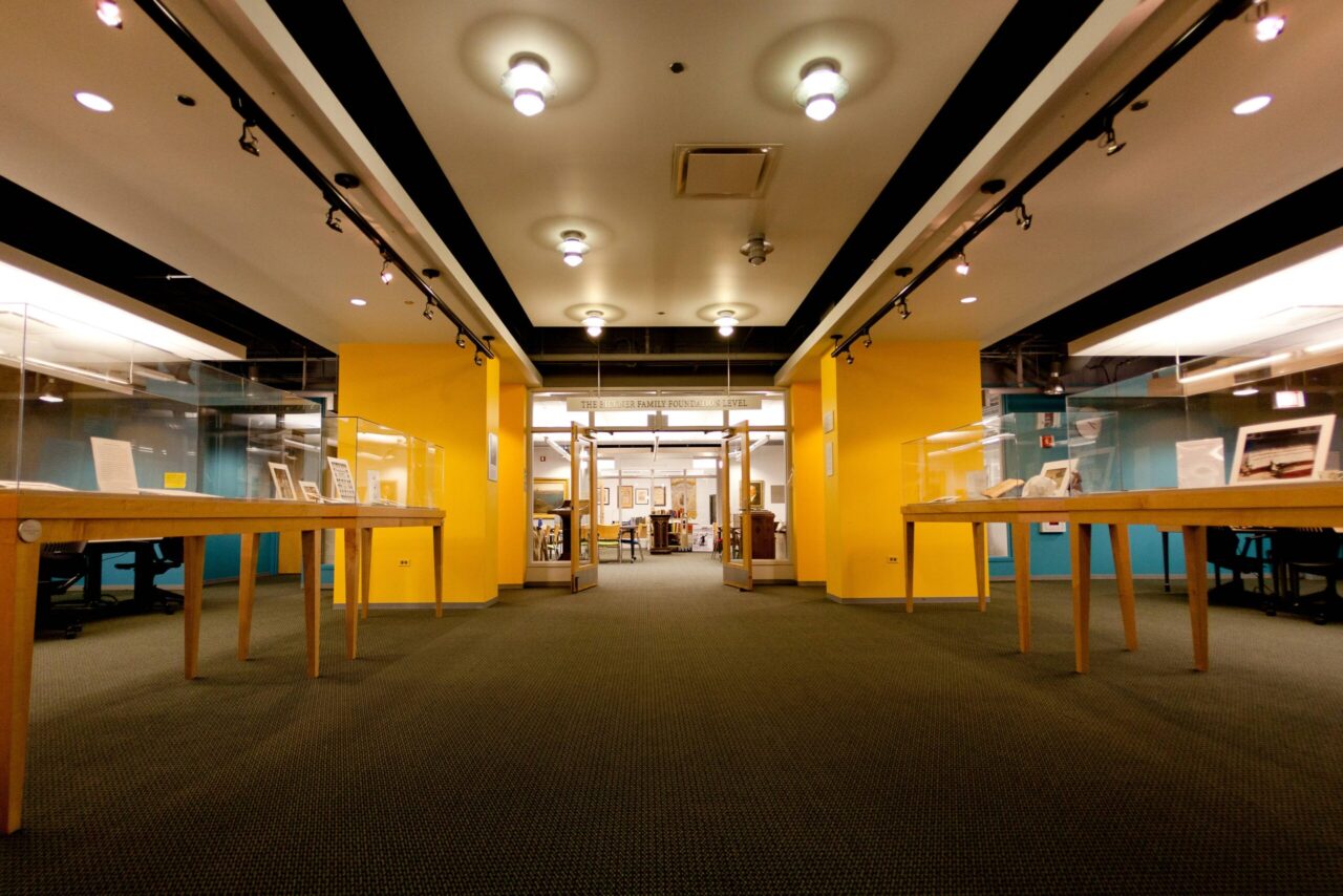 Interior of archival collection room at university library featuring display cases and yellow walls