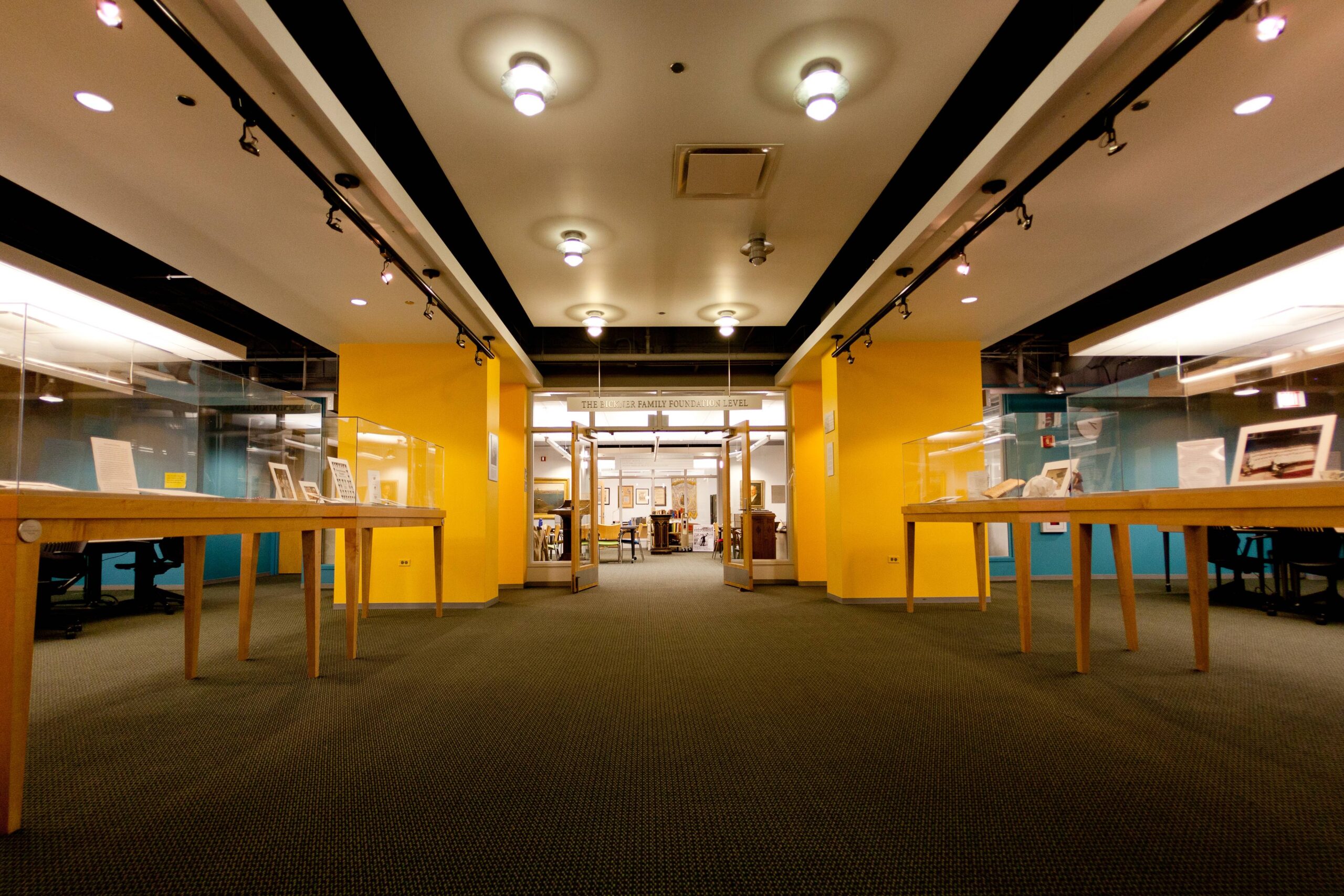 Interior of archival collection room at university library featuring display cases and yellow walls