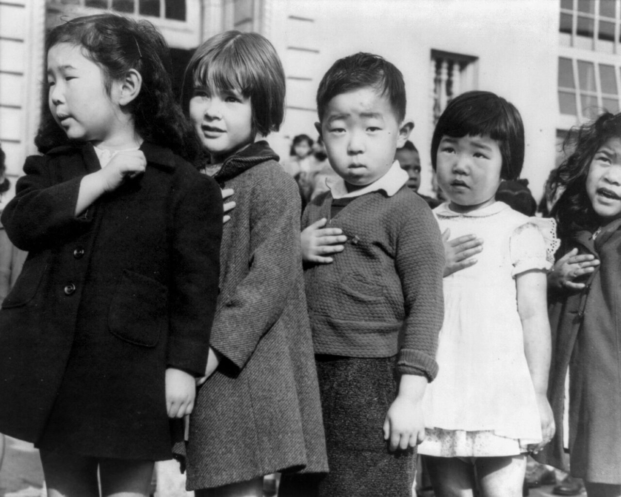 Black and white photograph of Japanese-American and white American children pledging allegiance to the flag