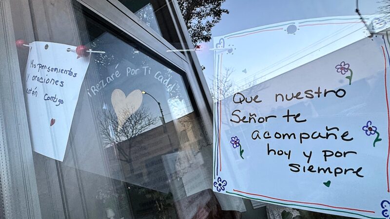cards written in Spanish hang along a string in the storefront window of a church