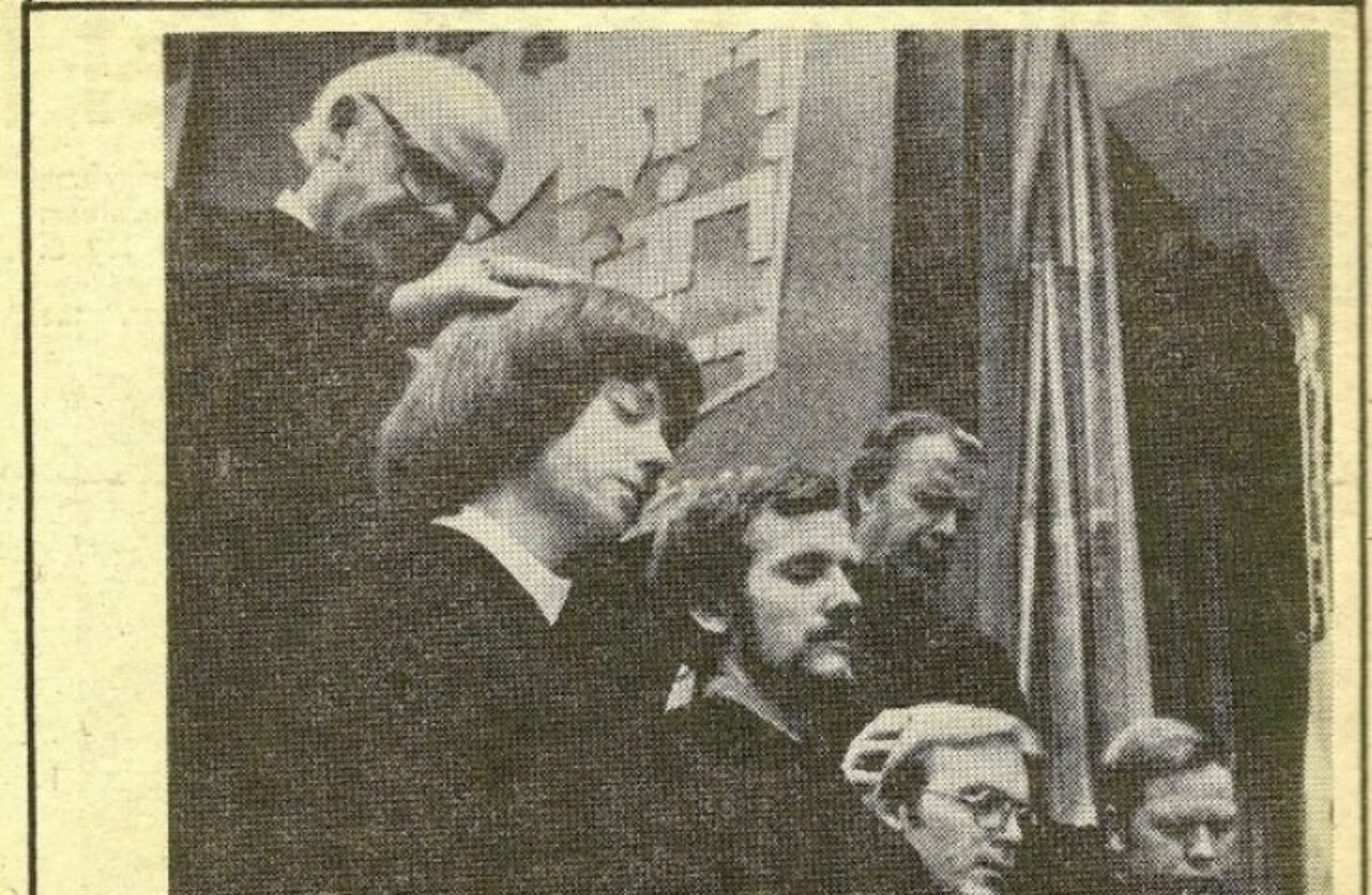 Black and white newspaper clipping featuring ordinands kneeling