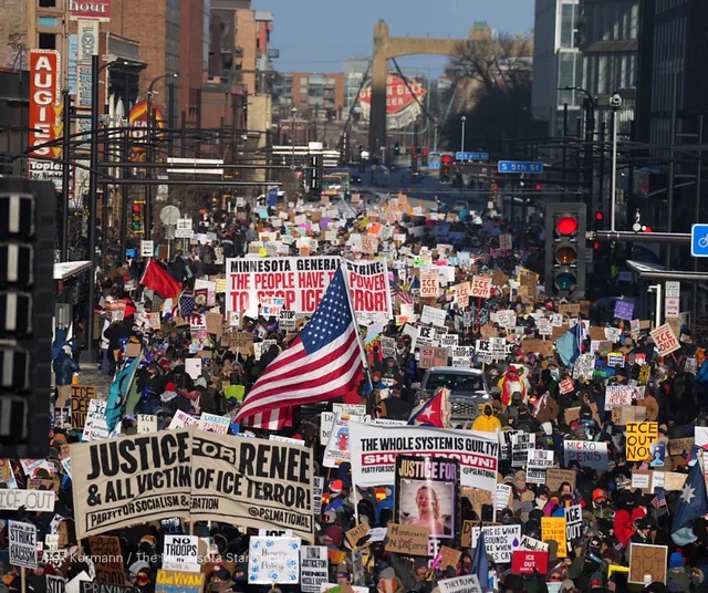 Large group of protesters with signs and flags fill street of downtown Minneapolis, Minnesota in January 2026