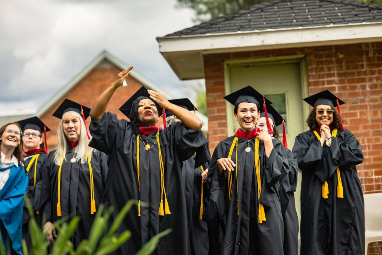 Diverse group of female masters graduates smiling and celebrating on their graduation day