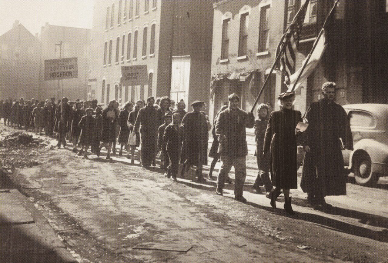 Protesters march down Chicago street in sepia photograph from 1940s